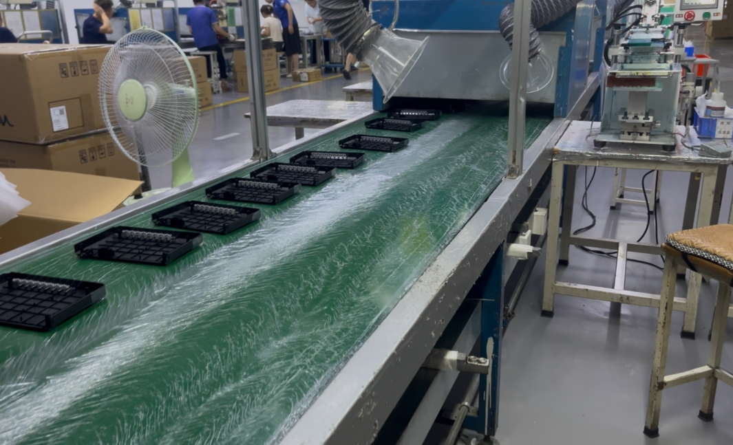 Assembly conveyor carrying molded components through a secondary processing station